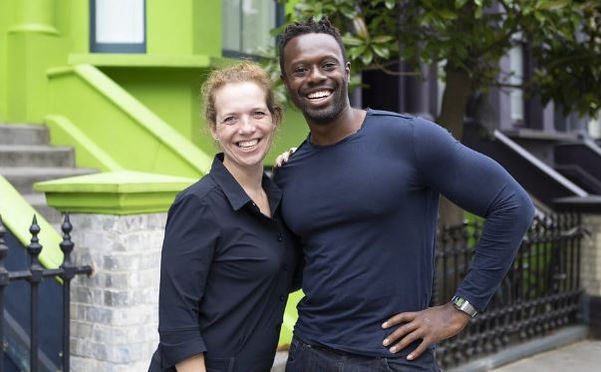 Two Stop Holding Back members smiling outside a green building